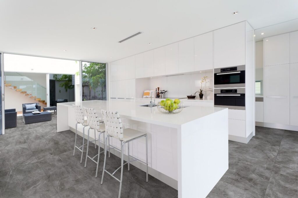 Cozinha branca com porcelanato Pulpis Grafite acetinado 84x84, marmorizado cinza